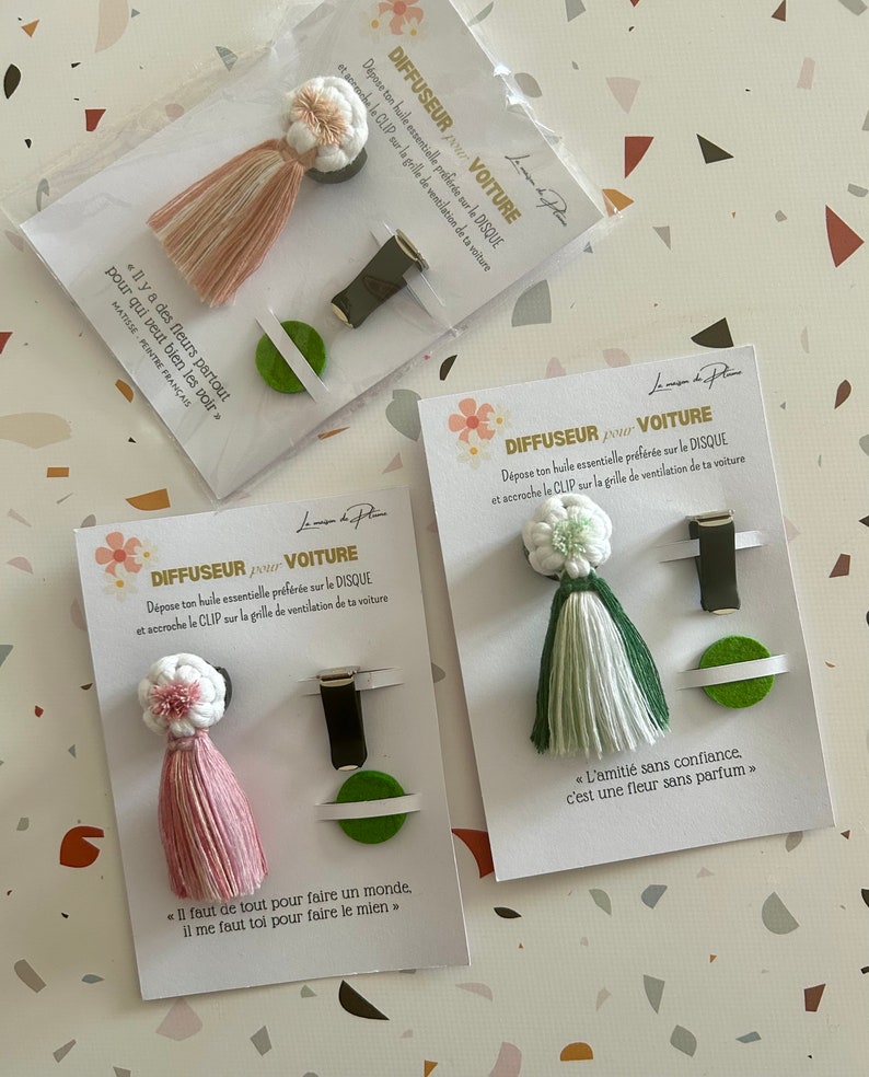 Peut inclure: Diffuseurs de parfum pour voiture avec des pompons roses, verts et blancs. Chaque diffuseur comprend un clip et un tampon en feutre. L'emballage pr&eacute;sente du texte et des citations en fran&ccedil;ais.
