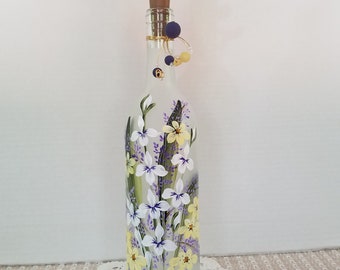 Frosted wine bottle.  Hand painted.  White, yellow and purple garden flowers.  Lights up.