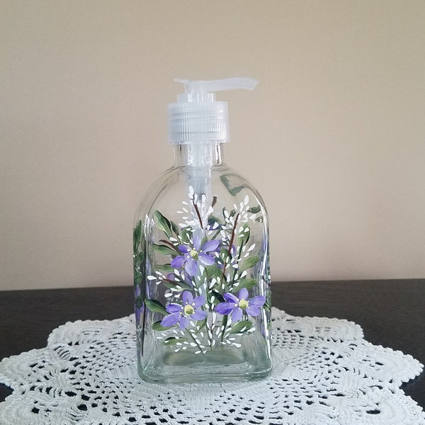 Glass soap / lotion dispenser.  Purple and white garden flowers painted on all 4 sides.  Hand painted.