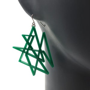 May include: Green geometric star-shaped earrings with a silver hook.