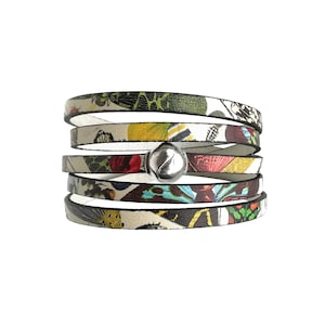 May include: Multi-layered leather bracelet with a silver charm. The bracelet features a colourful butterfly print.