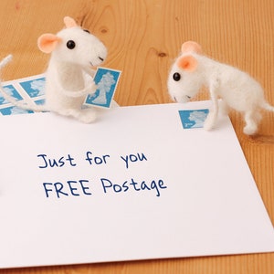 May include: A white envelope with the text "Just for you FREE Postage" written on it. Two white felt mice are on the envelope, one holding a blue stamp and the other looking at the stamp.