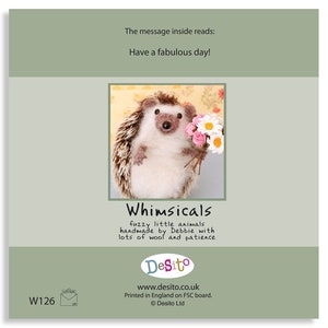 May include: A handmade felt hedgehog holding a bouquet of pink and white flowers. The card reads "Whimsicals fuzzy little animals handmade by Debbie with lots of wool and patience Desito www.desito.co.uk Printed in England on FSC board. &copy; Desito Ltd."