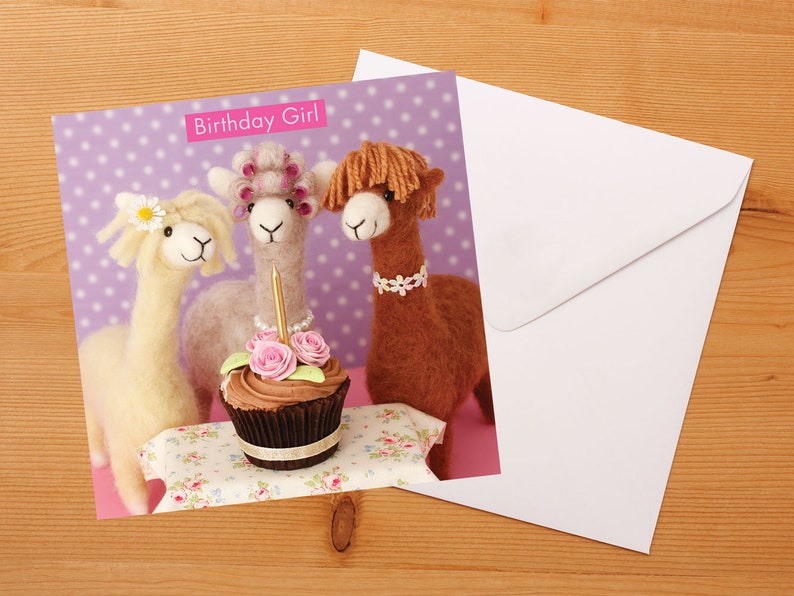 May include: A birthday card featuring three alpaca figurines with a cupcake and a single lit candle. The card has a purple background with white polka dots and the text "Birthday Girl".