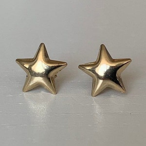 Könnte beinhalten: Ein Paar goldene Ohrringe in Sternform.