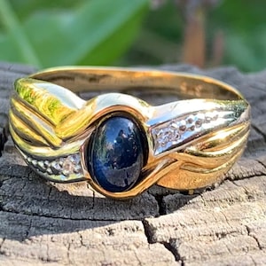 May include: A gold ring with a blue sapphire gemstone and small diamonds set in the band.