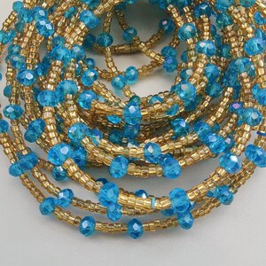 May include: A close-up of a beaded waist chain with alternating blue and gold beads. The chain is made of small, faceted beads that create a shimmering effect.