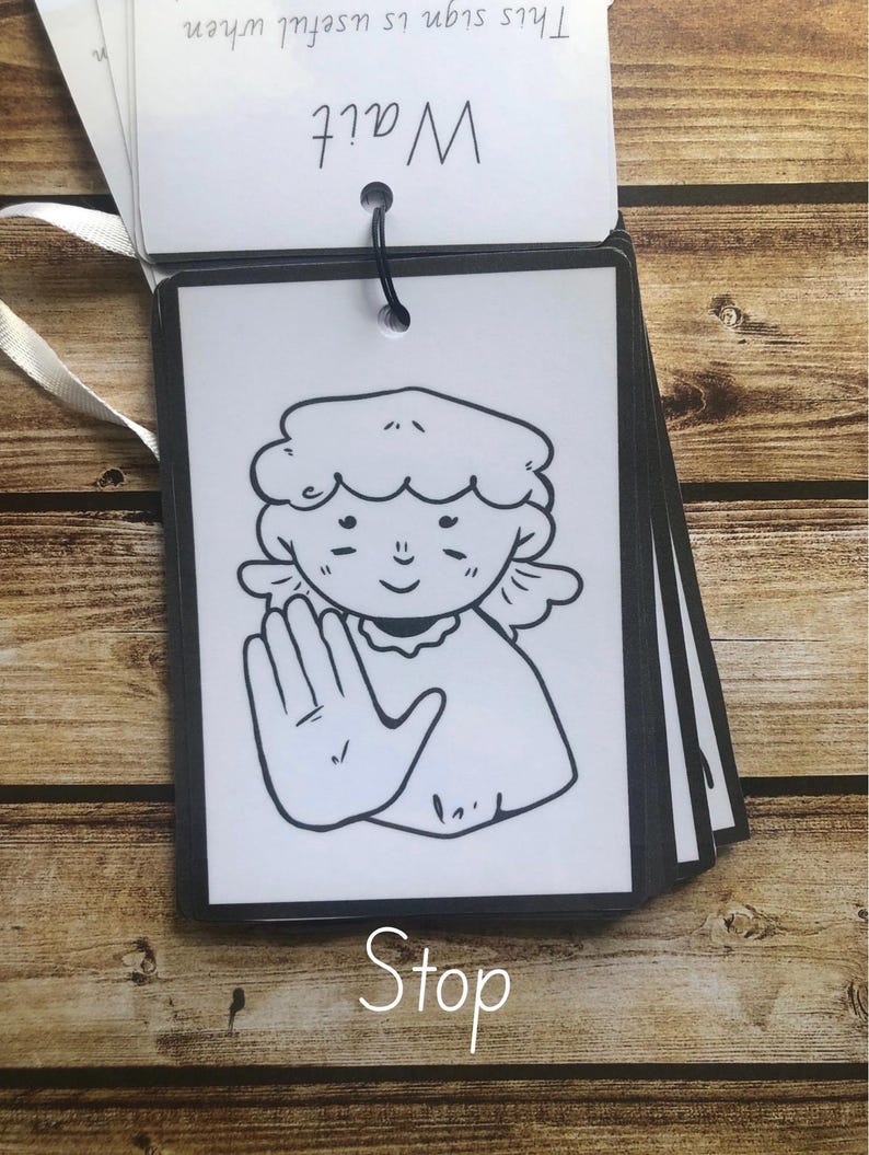 May include: Black and white illustration of a person making the sign language symbol for "stop". The image is on a white card with a black border and the word "Stop" written below the image. The card is part of a set of cards with the words "What?" and "This sign is useful when" written on the top card.