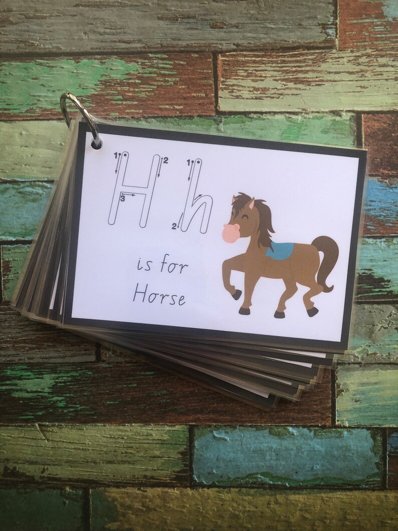 May include: A white card with a black border shows the letter H with tracing lines. The letter H is for Horse. A cartoon brown horse with a blue saddle is illustrated on the card.