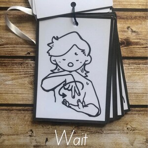 May include: Black and white illustration of a person signing the word "wait" in American Sign Language. The illustration is on a white card with black trim. The word "Wait" is written below the illustration.