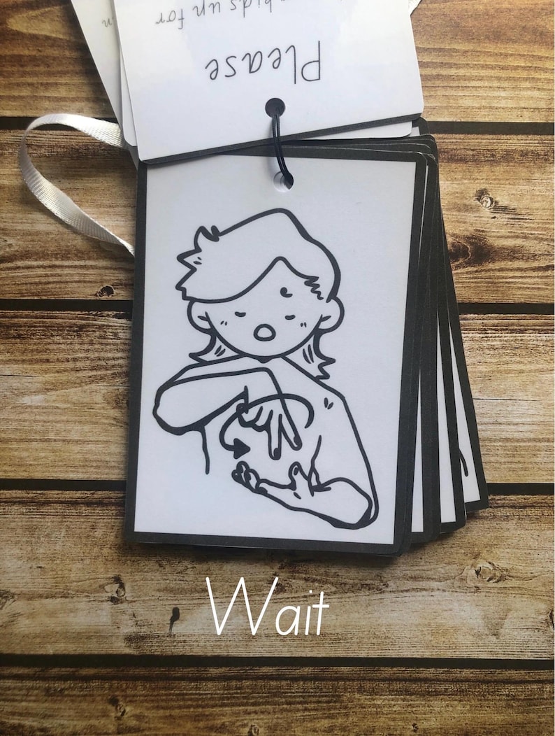 May include: Black and white illustration of a person signing the word "wait" in American Sign Language. The illustration is on a white card with black trim. The word "Wait" is written below the illustration.
