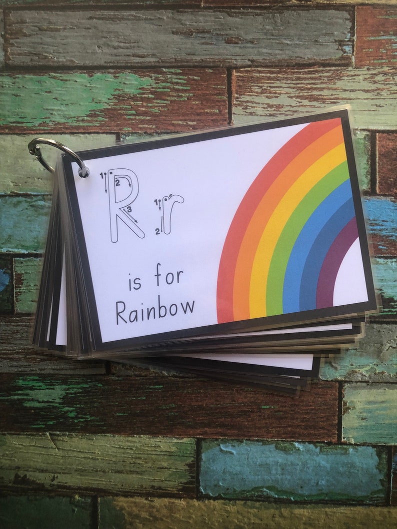 May include: A colourful rainbow with a black border is on a white card with the letter "R" and the words "is for Rainbow".
