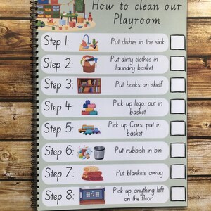 May include: A green and white checklist with the title "How to clean our Playroom". The checklist has eight steps with illustrations and checkboxes next to each step. The steps include putting dishes in the sink, putting dirty clothes in the laundry basket, putting books on the shelf, picking up lego and putting it in a basket, picking up cars and putting them in a basket, putting rubbish in a bin, putting blankets away, and picking up anything left on the floor.