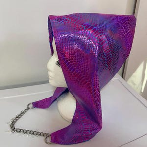 May include: A purple and blue iridescent hooded garment with a chain attached. The garment has a snake skin pattern.