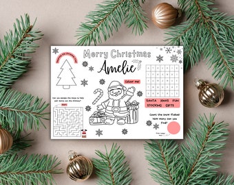 May include: A black and white printable Christmas activity sheet featuring a maze, a colouring page of Santa Claus, a word search, and a snowflake counting activity. The sheet is personalised with the name "Amelie" and the text "Merry Christmas".