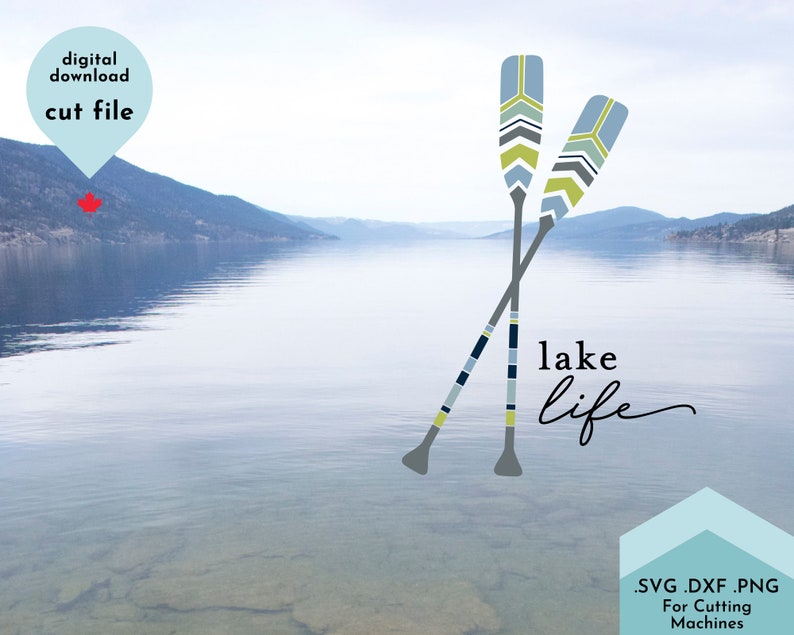 May include: Two crossed blue and yellow striped paddles with a lake scene in the background. The text "lake life" is written in a cursive font below the paddles.