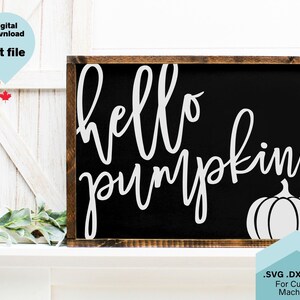 May include: A black sign with white text that reads "hello pumpkin" and a white outline of a pumpkin. The sign is in a wooden frame.