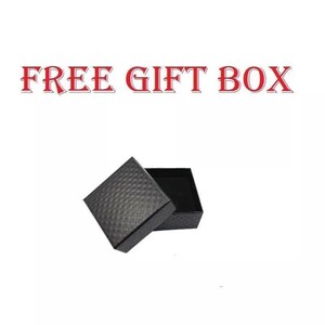 May include: An open black gift box with a textured, diamond-patterned exterior. The box is set against a white background, with the words "FREE GIFT BOX" in red letters above it.