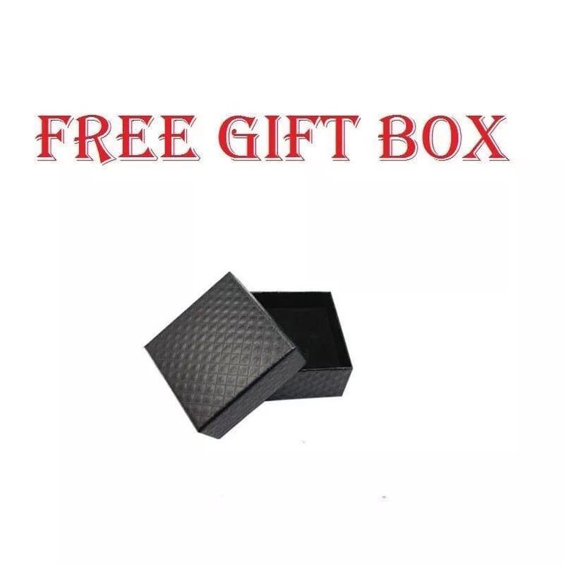 May include: An open black gift box with a textured, diamond-patterned exterior. The box is set against a white background, with the words "FREE GIFT BOX" in red letters above it.