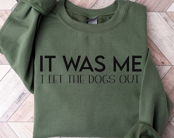 Puede incluir: Una sudadera verde con el texto "IT WAS ME I LET THE DOGS OUT" impreso en negro.