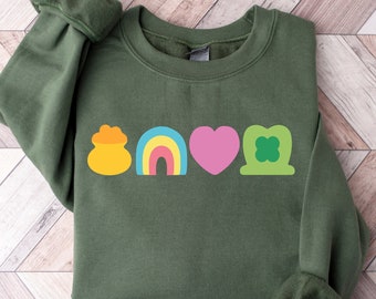 Puede incluir: Una sudadera verde con un diseño gráfico de una olla de oro, un arcoíris, un corazón y un trébol de cuatro hojas.