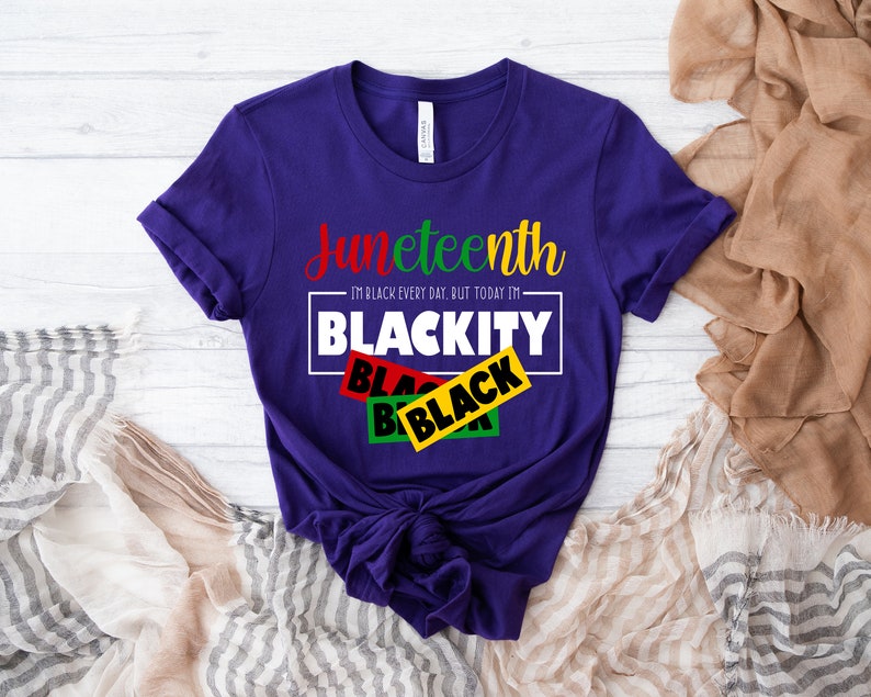 May include: Purple t-shirt with the text "Juneteenth I'm Black every day, but today I'm Blackity" in white with black, red, green, and yellow tape over the word "Black".