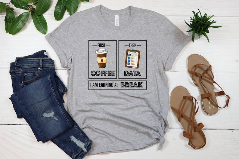 May include: Gray t-shirt with a graphic of a coffee cup and a checklist. The text reads "First - Coffee, Then - Data, I am earning a: Break".