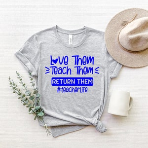 May include: Gray t-shirt with blue text that reads "Love Them Teach Them Return Them #teacherlife".