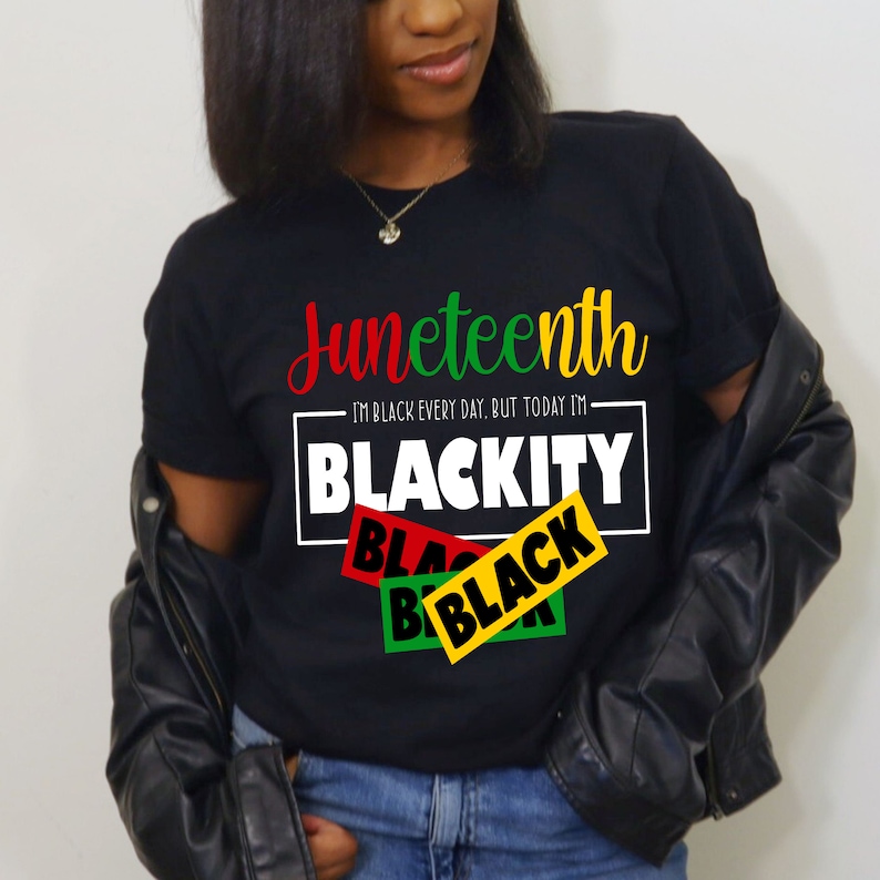 May include: A black t-shirt with the text "Juneteenth" in colorful lettering. The text "I'm Black every day, but today I'm Blackity" is printed in a white box with black text. The words "Black" are printed in red, green, and yellow boxes.