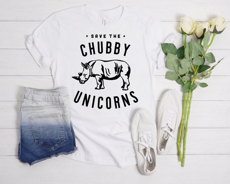 May include: White t-shirt with black text that reads "Save the Chubby Unicorns" and a black silhouette of a rhinoceros.