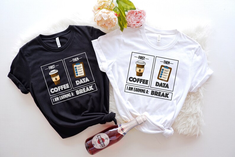 May include: Two t-shirts with a graphic design of a coffee cup and a checklist. The text on the shirts reads "First - Coffee, Then - Data. I am earning a: Break."
