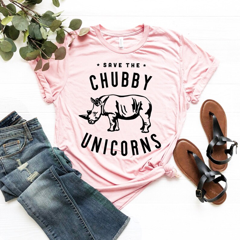 May include: Pink t-shirt with a black rhinoceros illustration and the text "Save the Chubby Unicorns".
