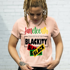 May include: A pink t-shirt with the text "Juneteenth" and "I'm Black every day, but today I'm Blackity Black Black" in black and red lettering.