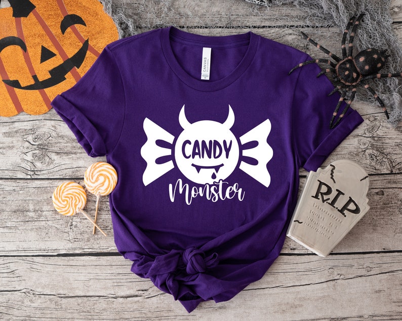 May include: Purple t-shirt with a white candy monster graphic and the text "Candy Monster".