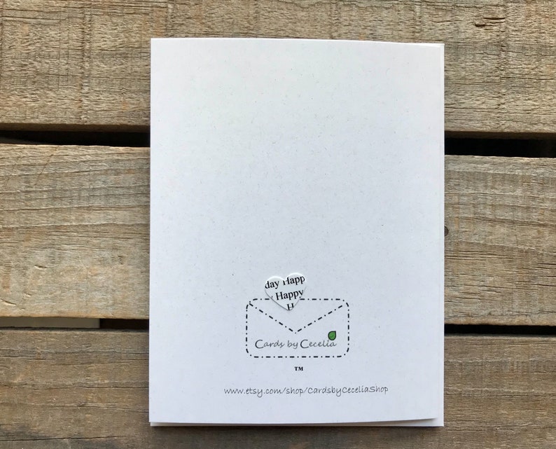 May include: White card with a black and white envelope design. The envelope has a heart-shaped flap with the text "Happy day" inside. The envelope also has the text "Cards by Cecelia TM" and a website address: "www.etsy.com/shop/CardsbyCeceliaShop".