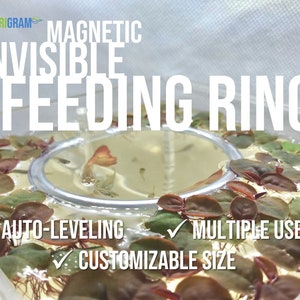 May include: A clear plastic aquarium with a silver magnetic feeding ring in the center. The ring is surrounded by red and green aquatic plants. The text "MAGNETIC INVISIBLE FEEDING RING" is at the top of the image. Below the ring, the text "AUTO-LEVELING", "MULTIPLE USES", and "CUSTOMIZABLE SIZE" is visible.