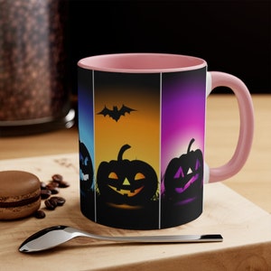 以下が含まれることがあります： ハロウィンをテーマにしたピンクと黒のセラミックマグカップ。マグカップには、カラフルな背景にコウモリのシルエットとジャック・オー・ランタンが4つ描かれています。