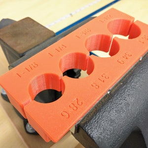 May include: Orange plastic pipe sizing gauge with five different size holes. The gauge is labeled with the following sizes: 1-1/8, 1-1/4, 1-3/8, 1-1/2, and 1-3/4.