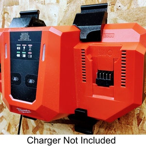May include: A red and black wall-mounted dual battery charger for power tools. The charger has a digital display with various indicators and a text label that reads "Charger Not Included".