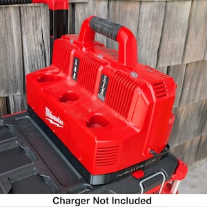 May include: A red Milwaukee power tool battery charger with a black handle and base. The charger features a white Milwaukee logo and the text "Charger Not Included" at the bottom.