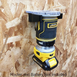 Op de afbeelding: Een zwarte en gele draadloze router gemonteerd aan een muur met een transparante kunststof basis. De router heeft een zwarte en gele batterij die aan de onderkant is bevestigd. "Router and Battery Not Included" staat in zwarte tekst op een witte achtergrond onderaan de afbeelding.
