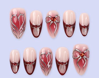 Unhas postiças para o Dia dos Namorados com laço prateado, coração e detalhes em vermelho | Unhas postiças médias amendoadas | Arte de unhas feita à mão para uso diário ou presente