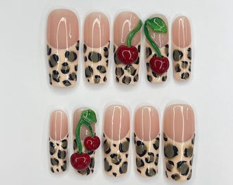 May include: Set of ten false nails with a leopard print design and a 3D cherry accent on each nail.