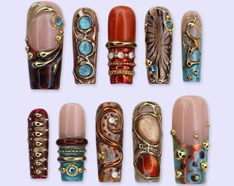 May include: A set of ten press-on nails featuring diverse designs including gold metallic accents, turquoise and orange circular inlays, raised gold beads, swirling patterns, and a mix of glossy finishes in shades of brown, red, and blue.