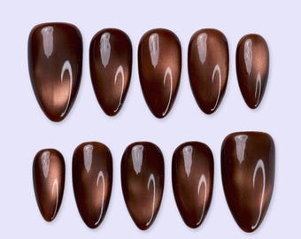 May include: A set of ten almond-shaped press-on nails in a deep, glossy chocolate brown finish. Each nail features a smooth, reflective surface with a subtle metallic sheen, arranged in two rows of five against a light background.
