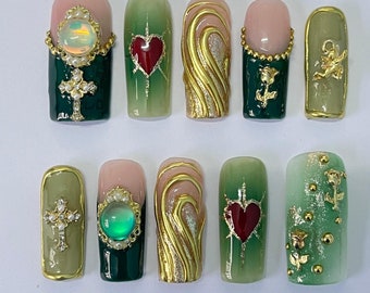 May include: Ten green and gold nail art designs featuring hearts, crosses, and swirls.