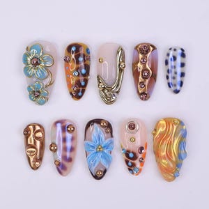 Uñas postizas azules con flor 3D y cromo bronce, forma almendrada mediana, uñas veraniegas metálicas terrosas para vacaciones, fiestas y estilo Y2K.