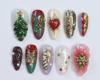 Könnte beinhalten: Zehn weihnachtliche Nageldesigns mit verschiedenen festlichen Elementen, darunter ein Weihnachtsbaum, Kugeln, ein Herz, Glitzer, ein Zuckerstange, eine Schneeflocke und eine Glocke.