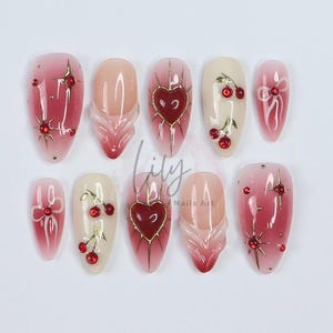 Elevate your nail with Red Aura Press-On Nails, featuring 3D gel hearts and cherries in medium almond, perfect for gifting or everyday glam