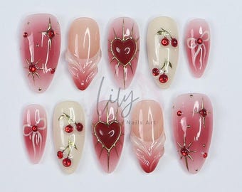 Elevate your nail with Red Aura Press-On Nails, featuring 3D gel hearts and cherries in medium almond, perfect for gifting or everyday glam
